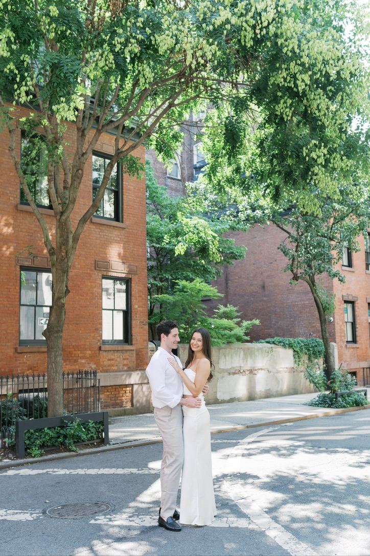 Leah and Jarryd embracing on a brick-lined street