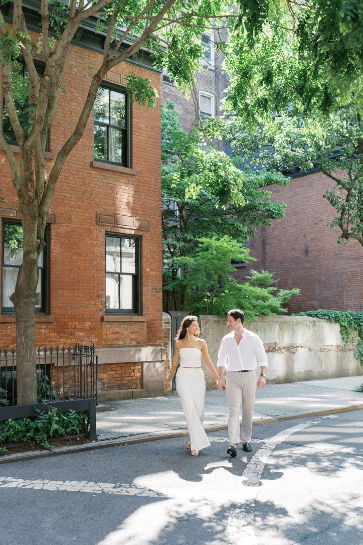 Leah and Jarryd walking past a brick townhouse