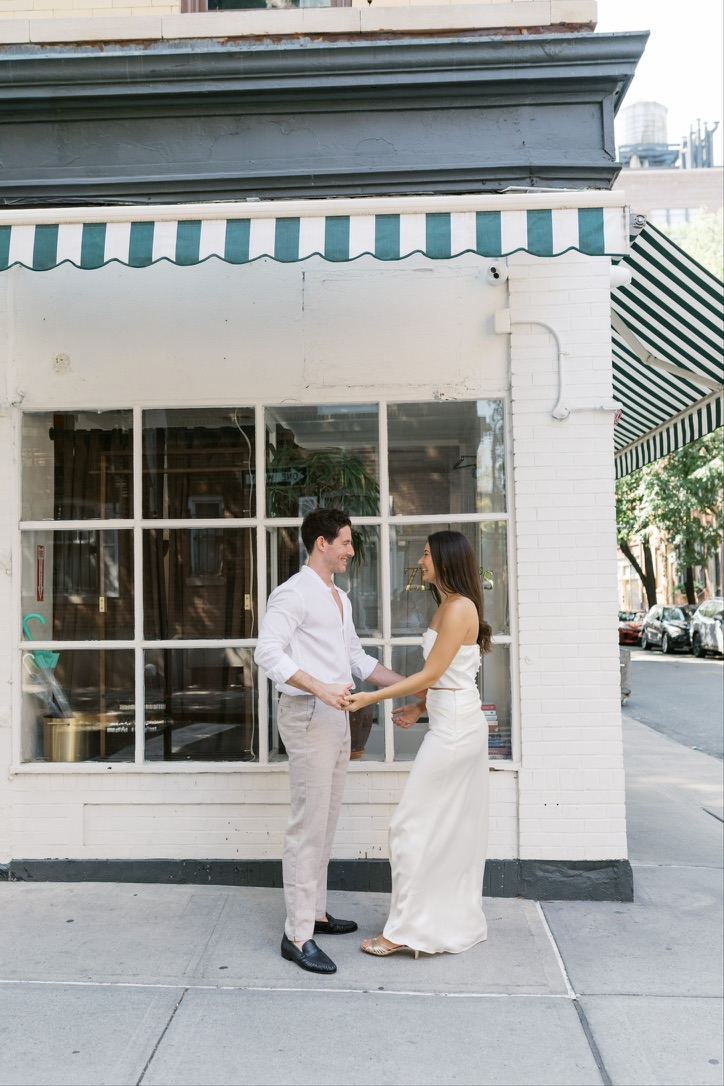 Leah and Jarryd holding hands under a green striped awning