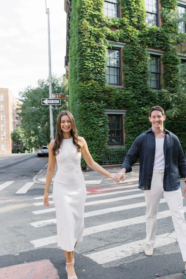 Leah and Jarryd crossing in front of an ivy-covered building